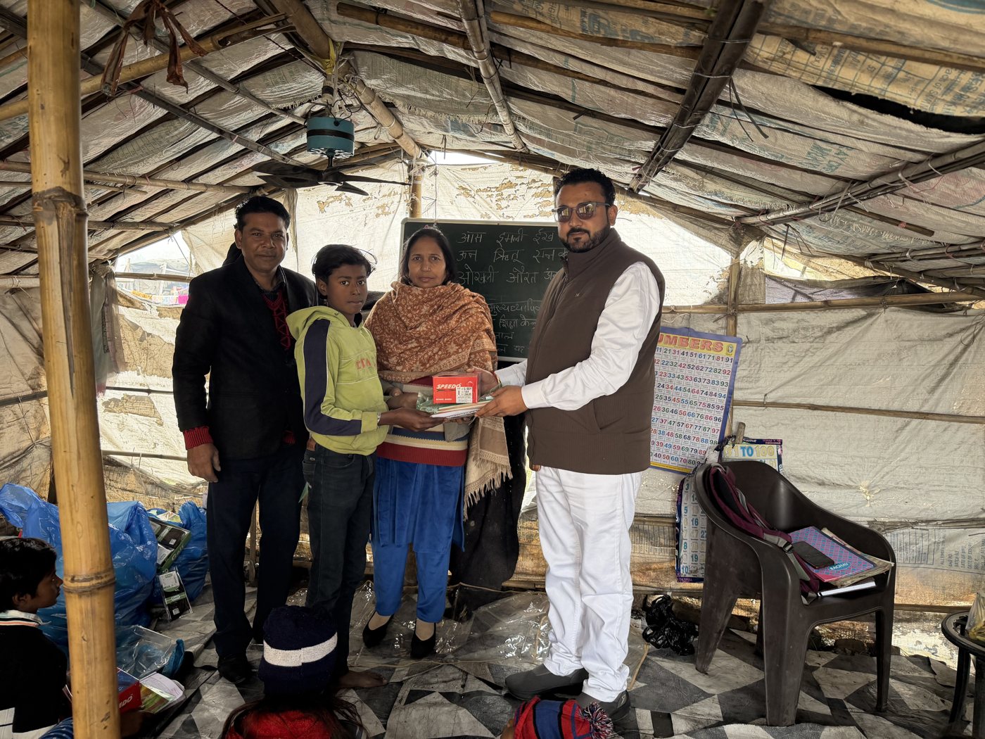 गरीब बच्चों को किताबें बाँटते हुए